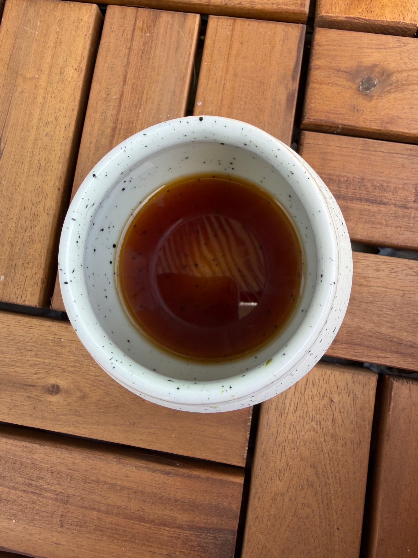 Amber coffee liquor in a speckled ceramic cup, seen from above