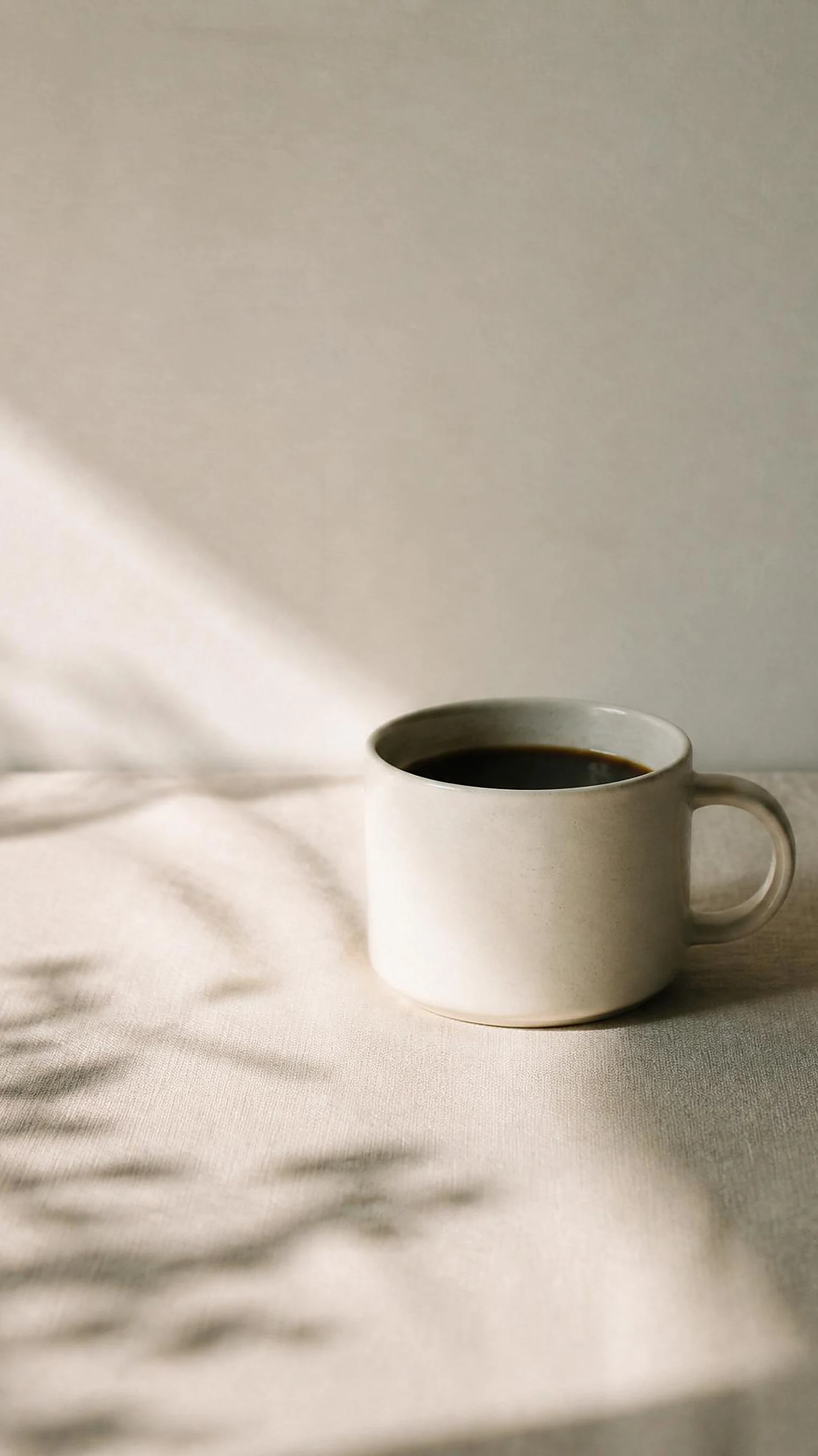 A ceramic cup of coffee in morning window light